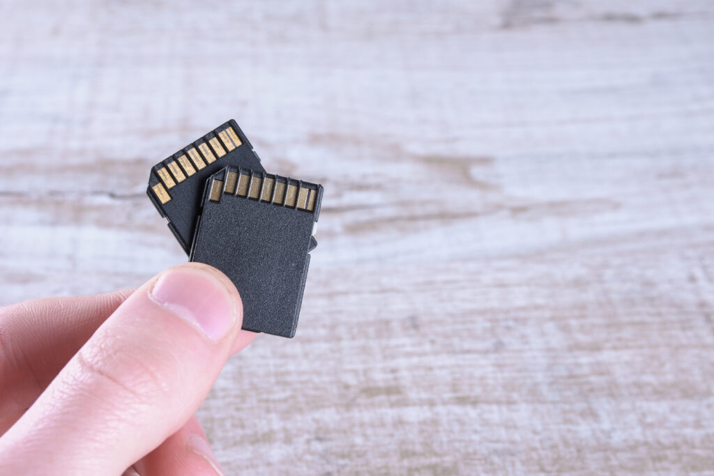 Pessoa segurando cartões de memória SD, mostrando o impacto do aumento de preços para fotógrafos